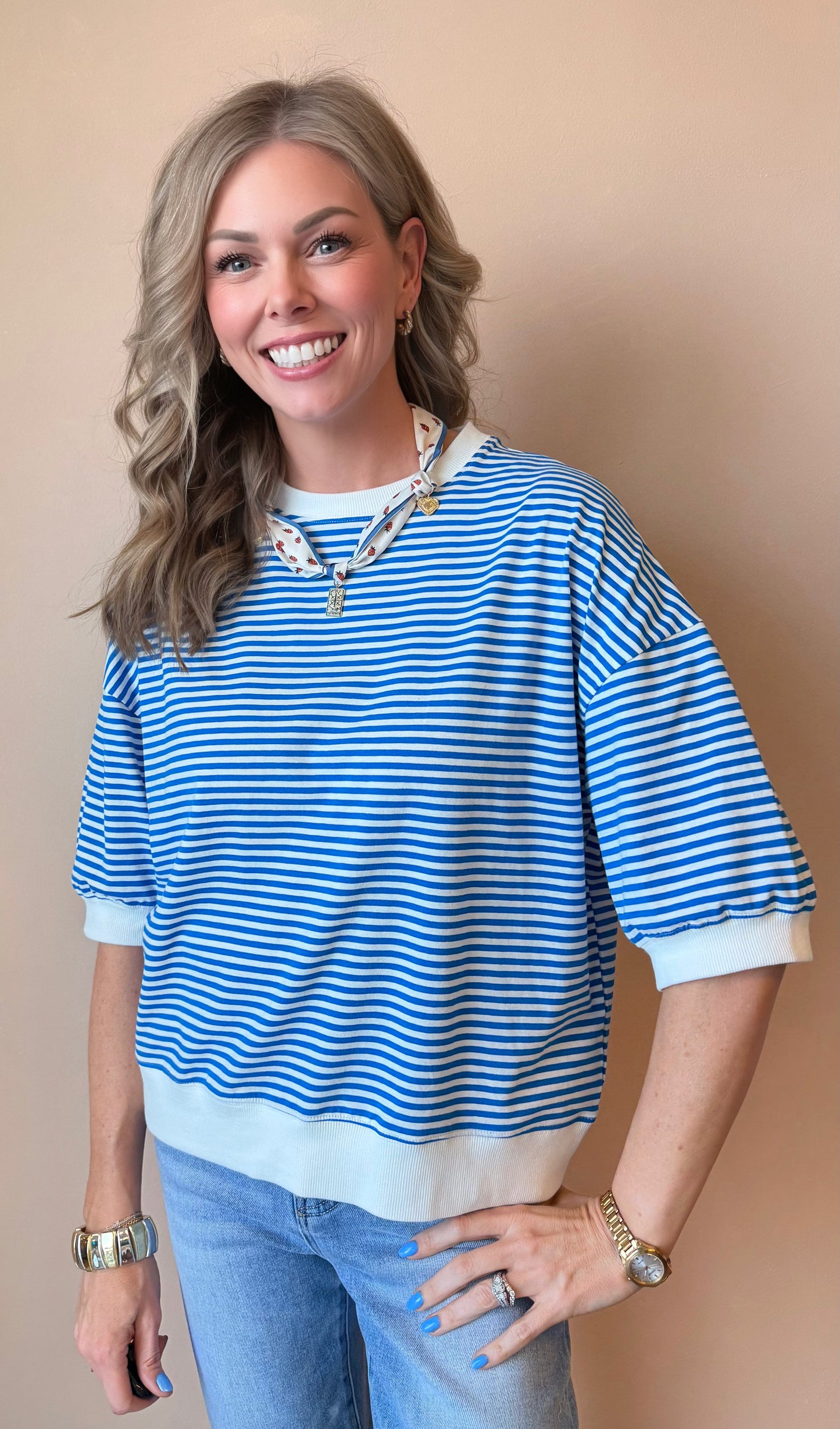 Woman wearing a blue and white striped shirt with a beige background
