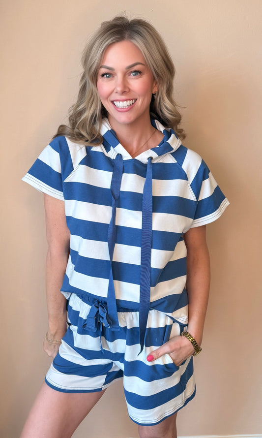 Woman wearing a blue and white striped outfit against a beige background
