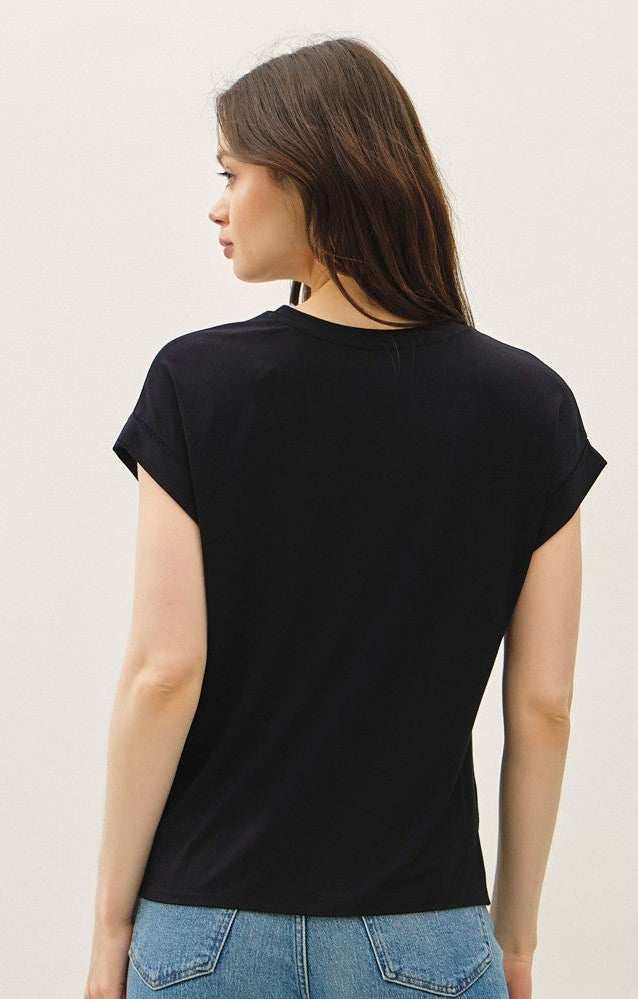 Person wearing a black t-shirt and blue jeans against a white background