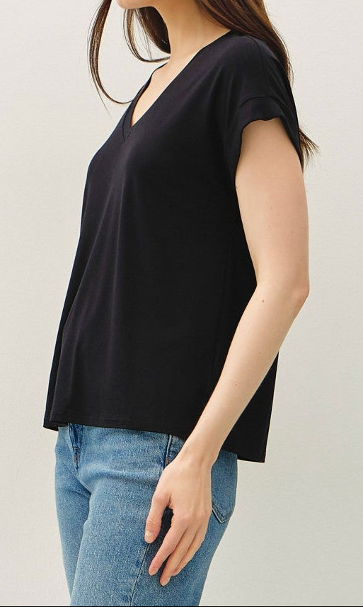 Woman wearing a black top and blue jeans on a white background