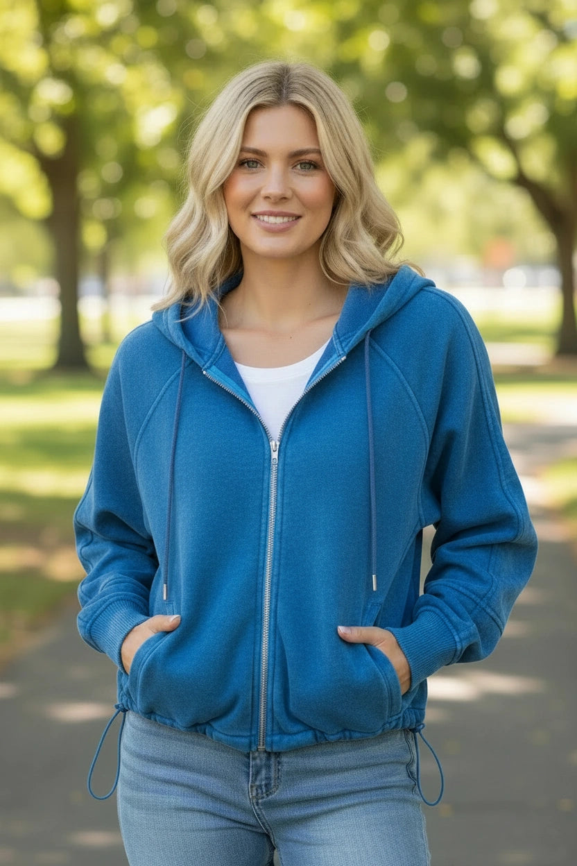Woman wearing a blue hoodie in a park setting