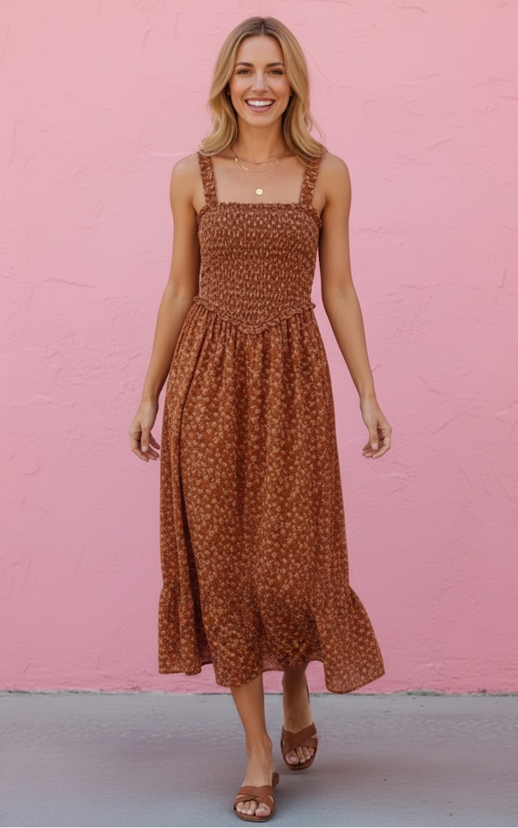 Woman wearing a brown floral dress against a pink wall