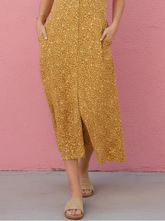 Woman wearing a yellow dress against a pink wall