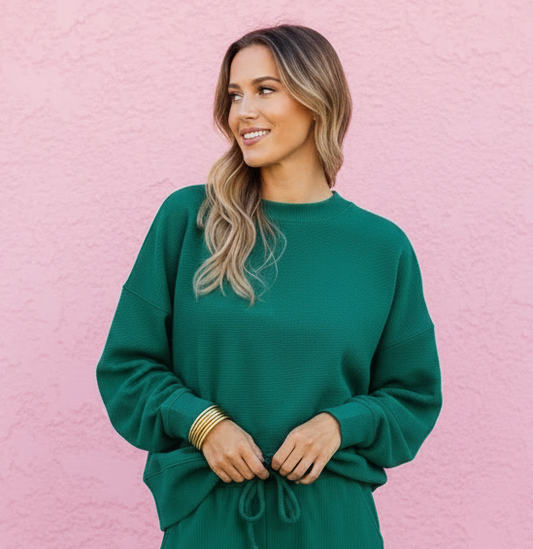 Woman wearing a green outfit against a pink wall