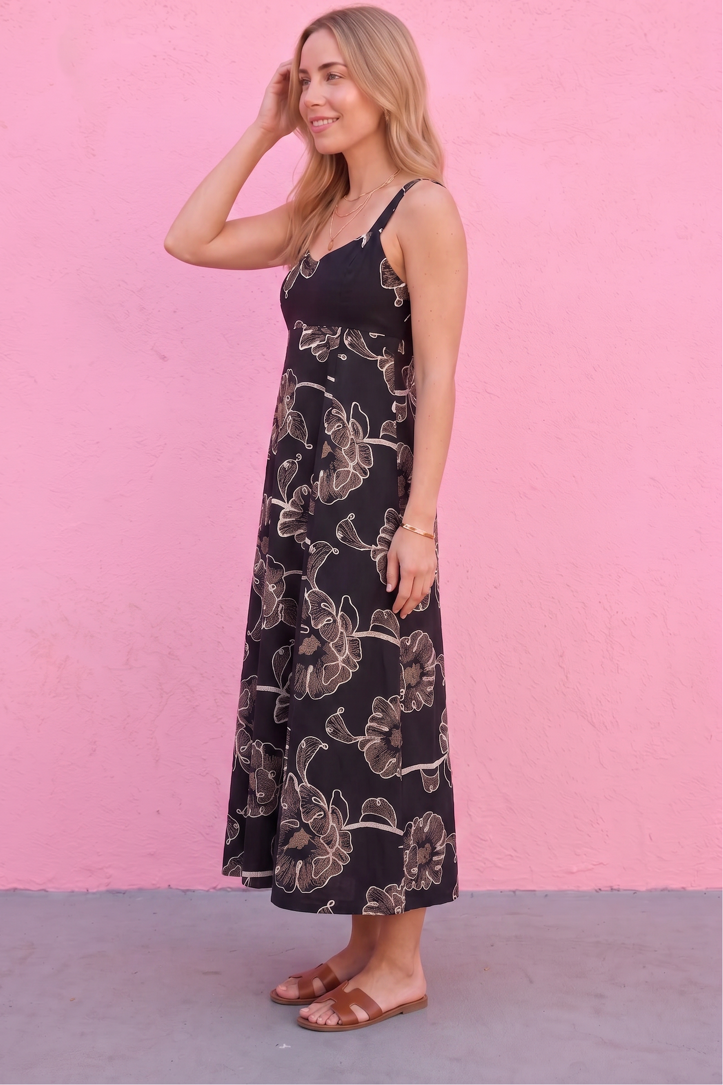 Woman wearing a floral dress against a pink wall