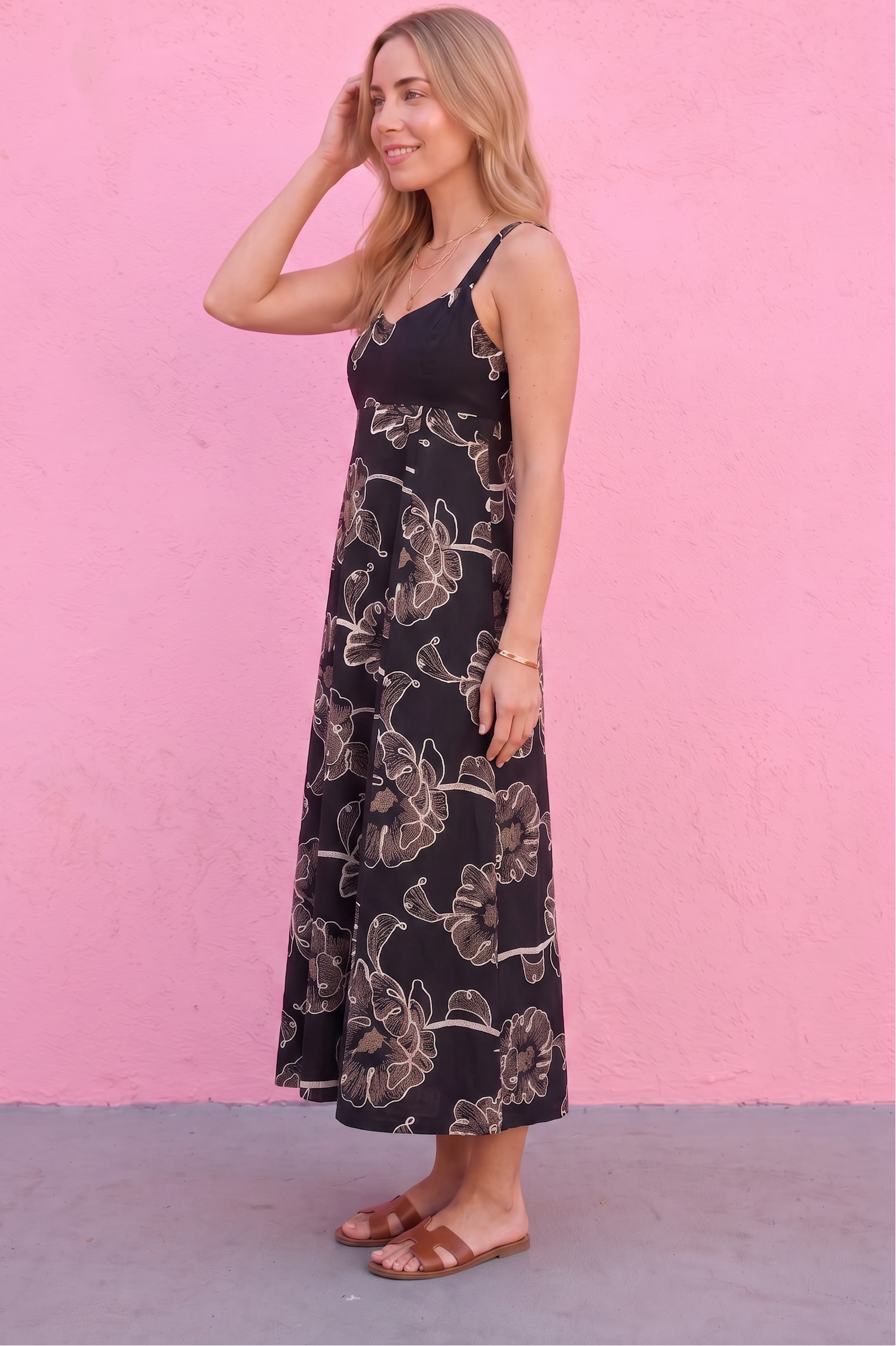 Woman wearing a floral dress against a pink wall