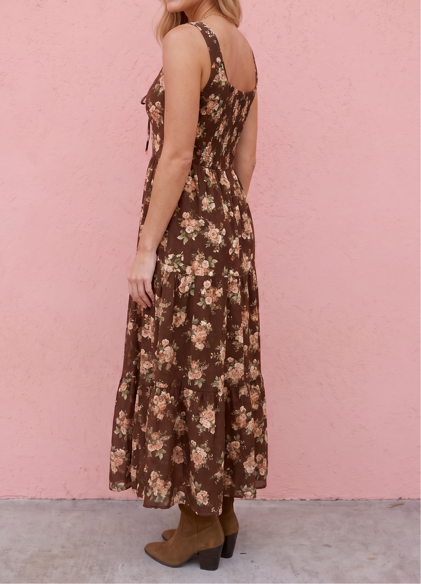 Woman wearing a floral dress against a pink wall