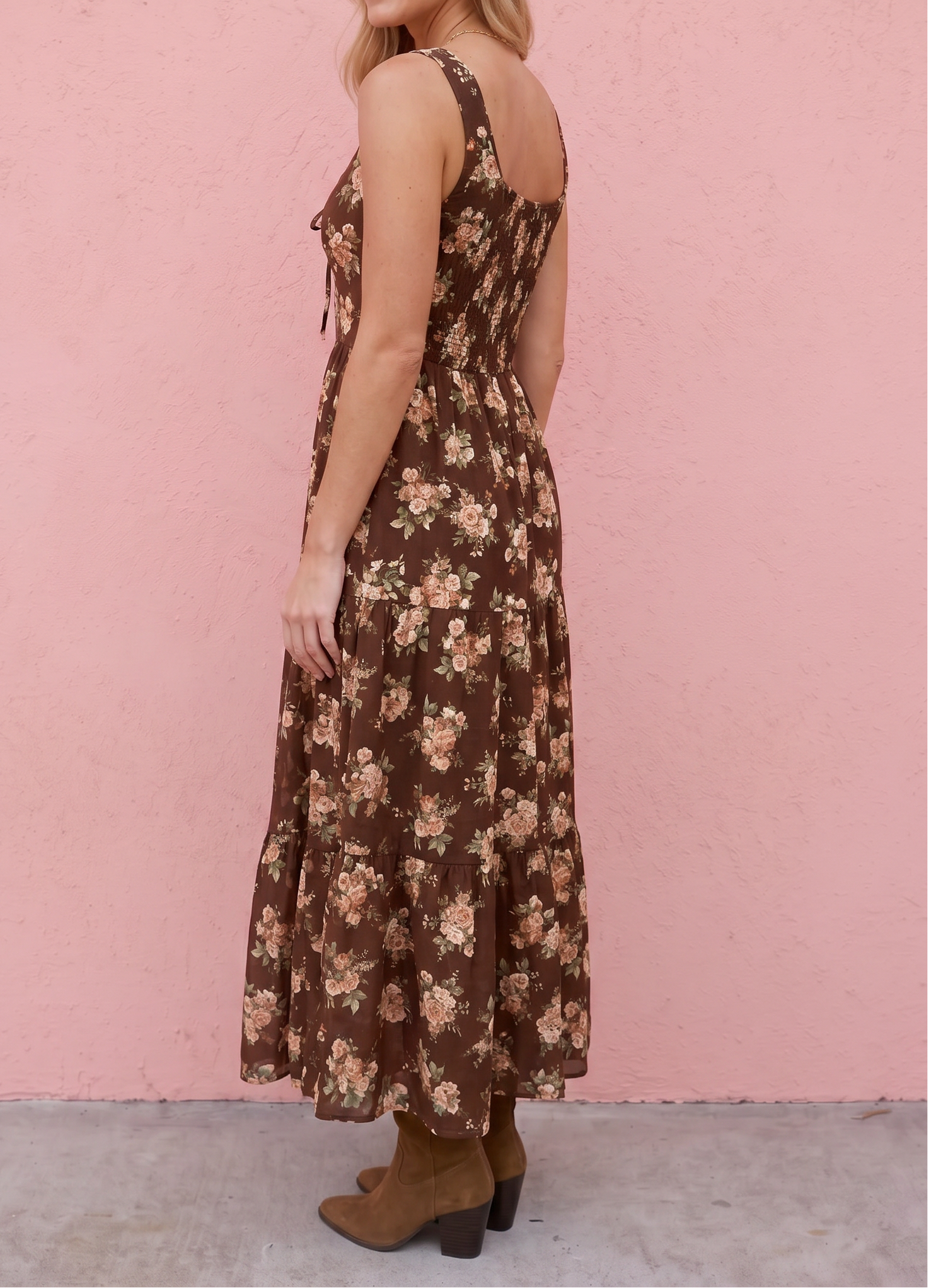 Woman wearing a floral dress against a pink wall