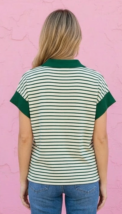 Person wearing a striped shirt and jeans against a pink wall