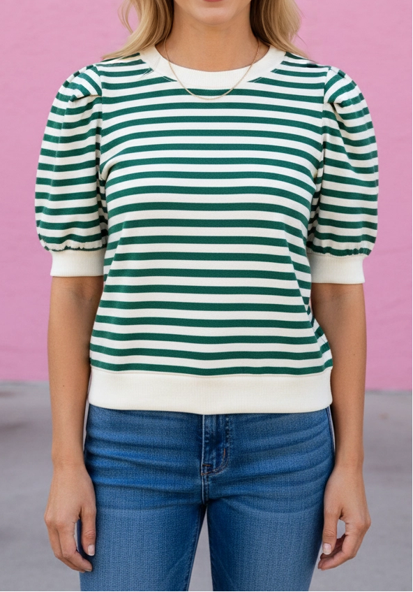 Woman wearing a green and white striped shirt against a pink background