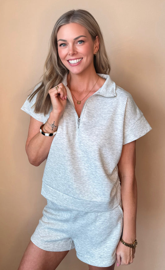 Woman wearing a light gray outfit against a beige background