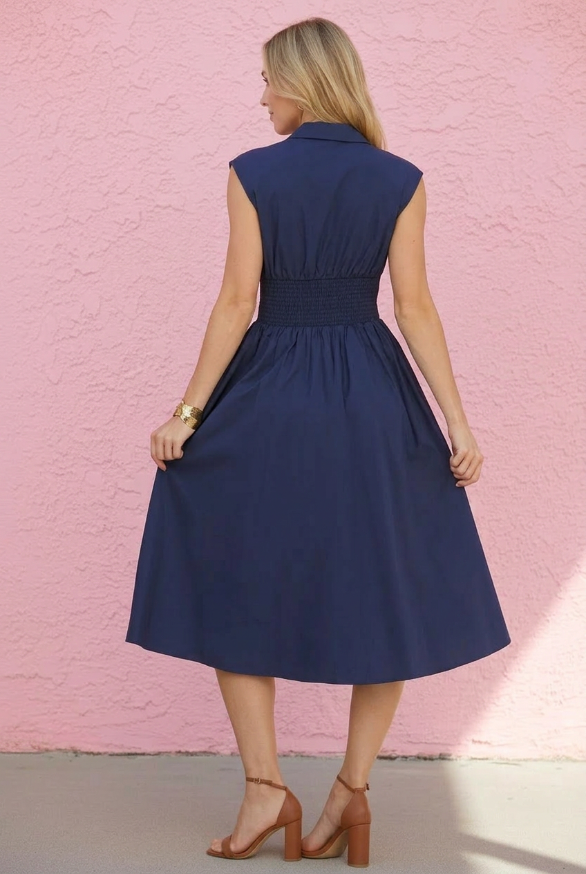 Woman wearing a navy dress against a pink textured wall